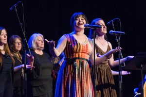 Group of performers on stage singing at the Bridge Meadows 2018 auction & gala